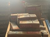 Plusieurs cartons de Veluxx sont empilés sur une palette dans un entrepôt