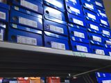 many blue boxes on a shelf in a store