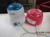 two containers of water sitting on a table next to each other