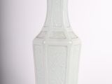 a white vase that is sitting on a white surface