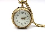 a gold pocket watch with a chain on a white background