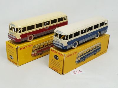 trois bus miniatures sont posés sur des cartons, sur une surface blanche