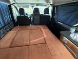 a bed in the back of a van with a mattress on it