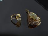 a close up of a gold ring and ring with a tear shaped stone