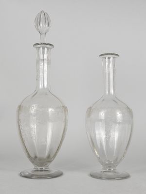 two clear glass vases sitting next to each other on a white surface