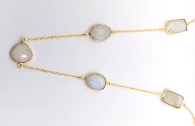 a close up of a necklace with three different colored stones on it