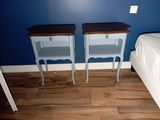 two blue nightstands sitting next to each other on a wooden floor