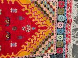 a close up of a red rug on a floor with a black background