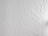 someone is drawing a heart on the wall with white paint