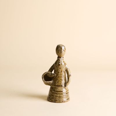 une figurine représentant une femme tenant un bol