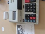 une calculatrice posée sur une table à côté d'un livre