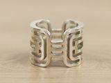 sterling silver ring with inter links on a wooden surface