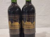 two bottles of wine sitting on top of a table next to a price tag