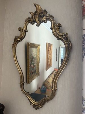 un miroir accroché au mur à côté d'un vase