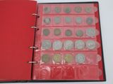 a red book with a bunch of coins inside of it