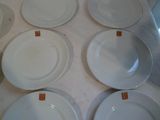 six assiettes blanches avec des étiquettes sur une table