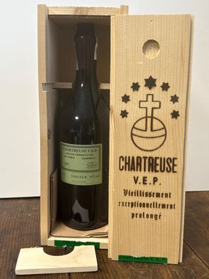 une caisse en bois contenant une bouteille de vin, posée sur une table