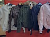 un grand nombre de vestes suspendues à un présentoir dans un magasin