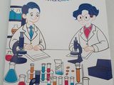 two children in lab coats sitting at a table with microscopes