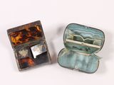 two pieces of jewelry in a case on a white surface
