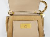 a close up of a beige purse with a chain around it