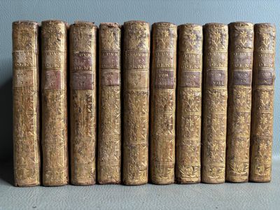 six old books are lined up on a table