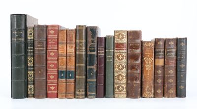 de nombreux livres anciens alignés en rang sur une surface blanche