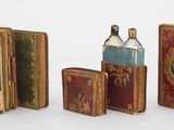 quatre livres et une bouteille posés les uns à côté des autres sur une table