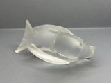 a clear glass fish shaped object on a table