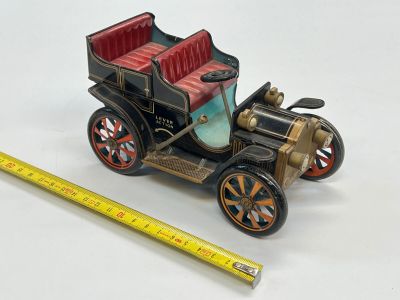une petite maquette de voiture posée sur une surface blanche