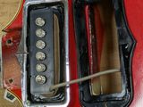 a close up of a red electric guitar that is being worked on
