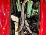 a red car with a bunch of pipes in the trunk