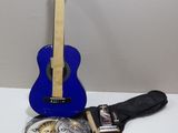 blue guitar with a case and a guitar strap sitting on a table