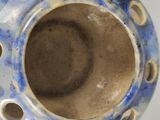 a blue and white vase with holes in it