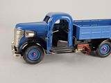 a blue toy truck with a door open on a white surface