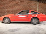 a red car parked in a garage with a brick wall in the background