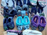 several pairs of slippers are laid out on a wooden floor