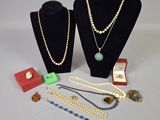 two necklaces and a ring on display on a table