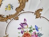 two plates with flowers painted on them on a table