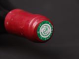 a close up of a bottle of wine with a red cap