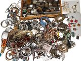 a wooden box full of assorted jewelry on a white surface