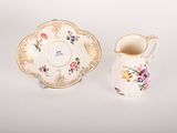 an image of a small cup and saucer sitting next to each other on a white surface