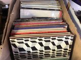 une boîte remplie de disques vinyles posée par terre