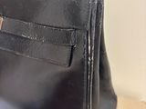 black leather handbag sitting on a cardboard box on a table