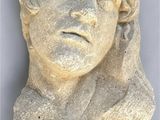 a close up of a statue of a man with a flower on his head