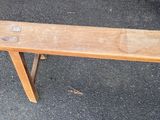 a wooden bench that is sitting on the pavement
