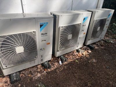 several air conditioners are lined up in a row on the side of a building