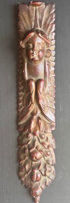une plaque métallique sur laquelle est représenté un visage, fixée au mur
