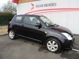 a picture of a small black car parked in front of a building