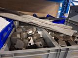a pile of metal parts in a bin in a warehouse